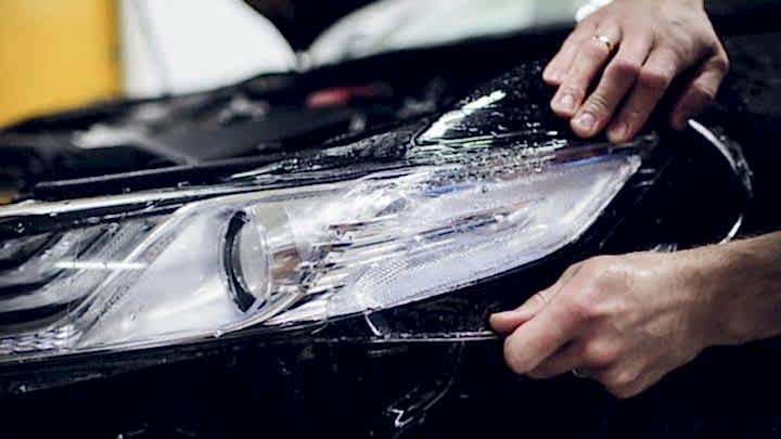 Worker hands installs car paint protection film